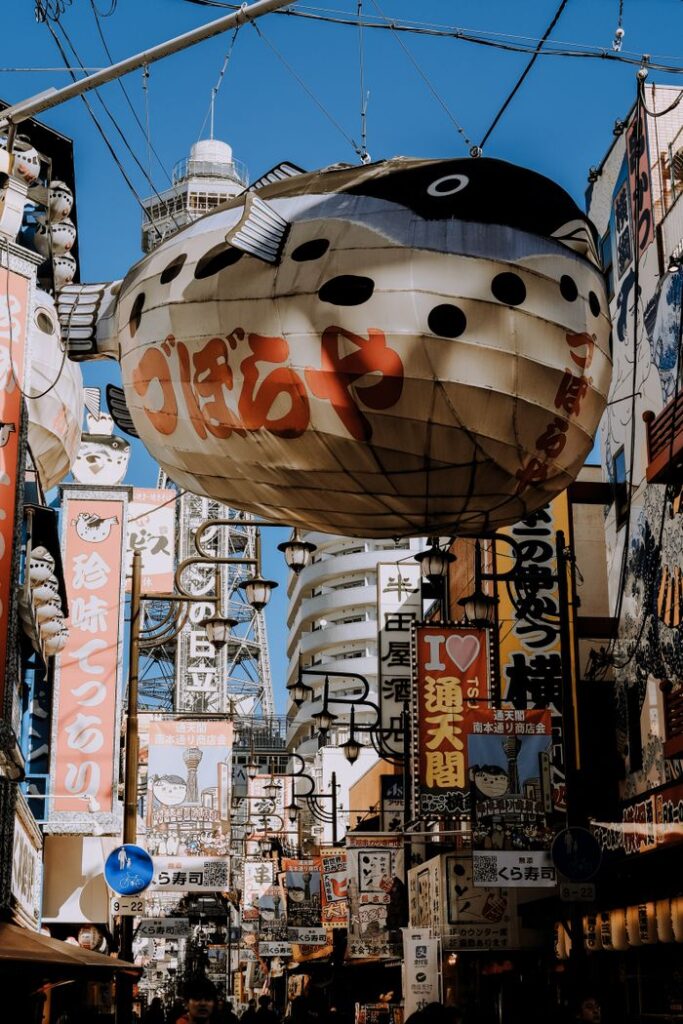 Dynamic street view of Shinsekai, Osaka, showcasing lively signs and architecture.